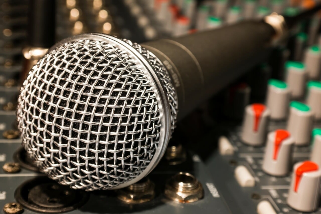 A microphone laying on a Radio Desk to show Podcasting To Radio